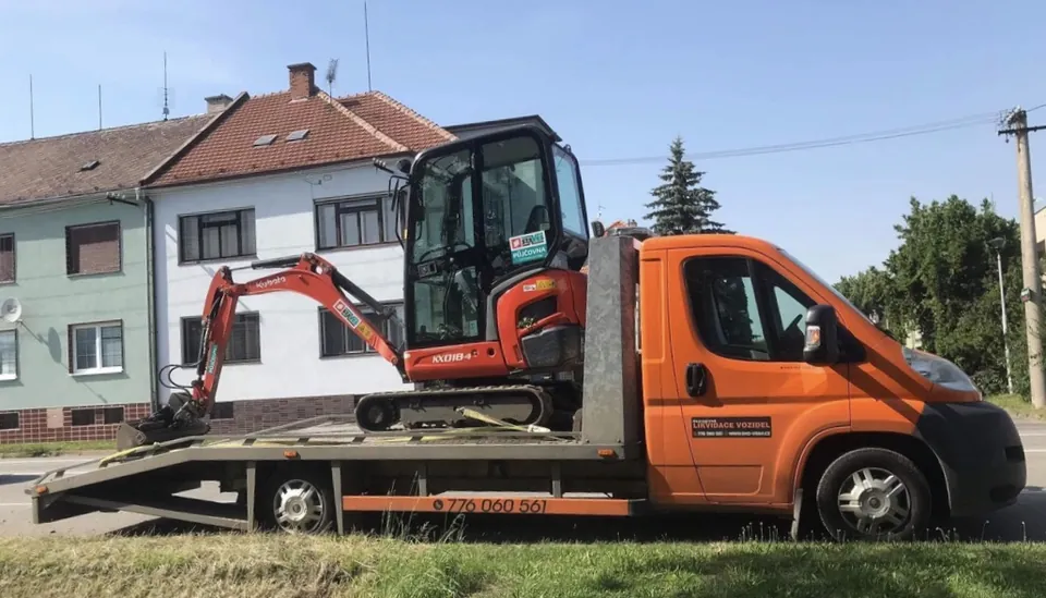 Minibagr naložený na odtahové plošině